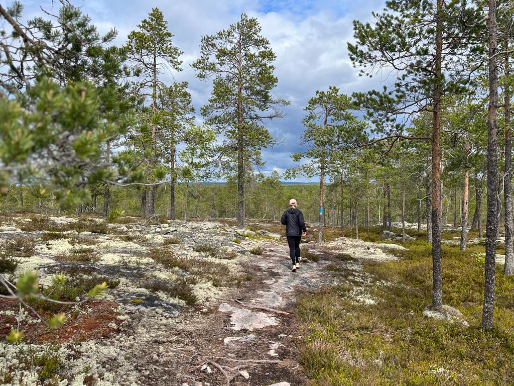 Nainen kävelee luontopolulla.